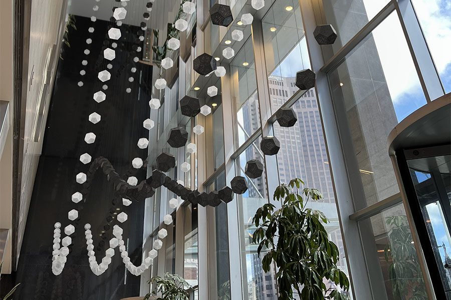 Suspended kinetic geometric light installation in modern atrium