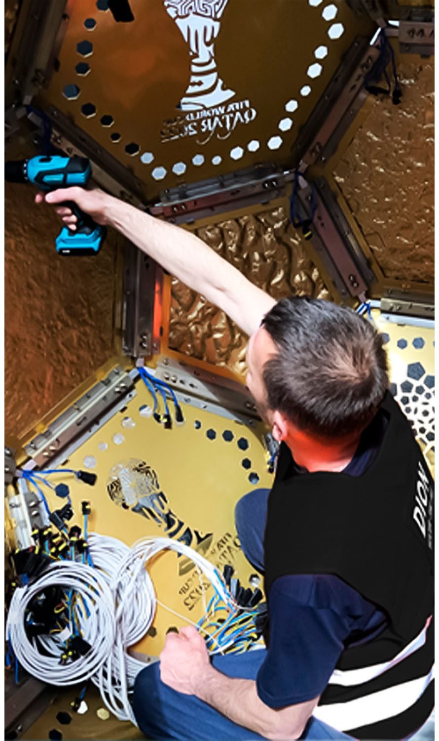 Technician DION assembling internal wiring inside a decorative metal structure