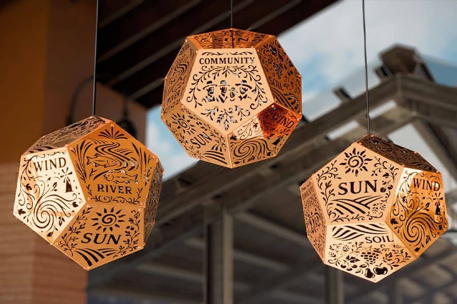 close-up of perforated kinetic dodecahedron module with different symbol and text engravings